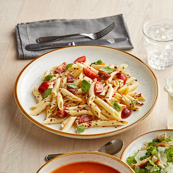 An Acopa stoneware plate with pasta and salad on it.