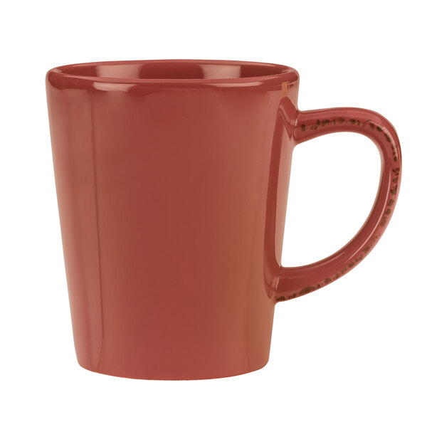 A Libbey barn red porcelain mug with a handle.