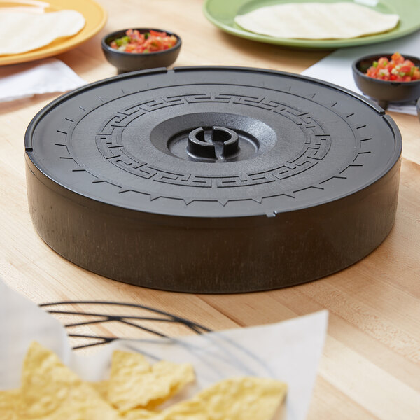 A Carlisle black plastic tortilla server on a table with tortillas and salsa.