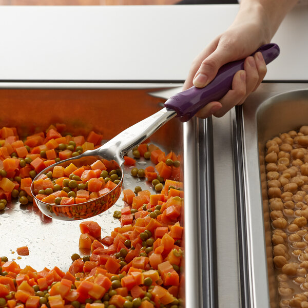 A person using a Vollrath Jacob's Pride purple Spoodle to scoop food from a bowl.
