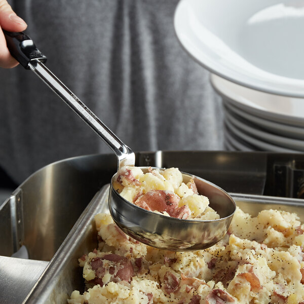 A person using a Vollrath Black Solid Spoodle to scoop food from a bowl.