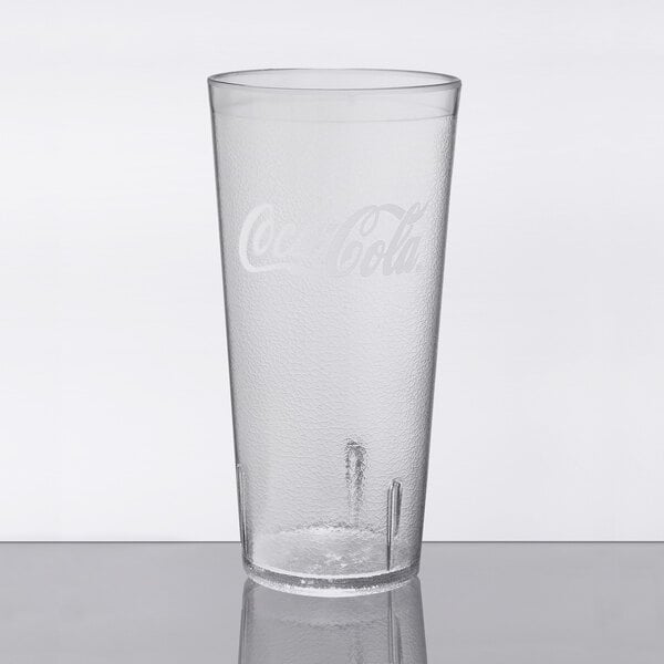 A clear plastic cup with a Coca-Cola logo on it.