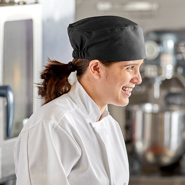 A woman wearing a black Choice mesh chef's hat smiles at the camera.