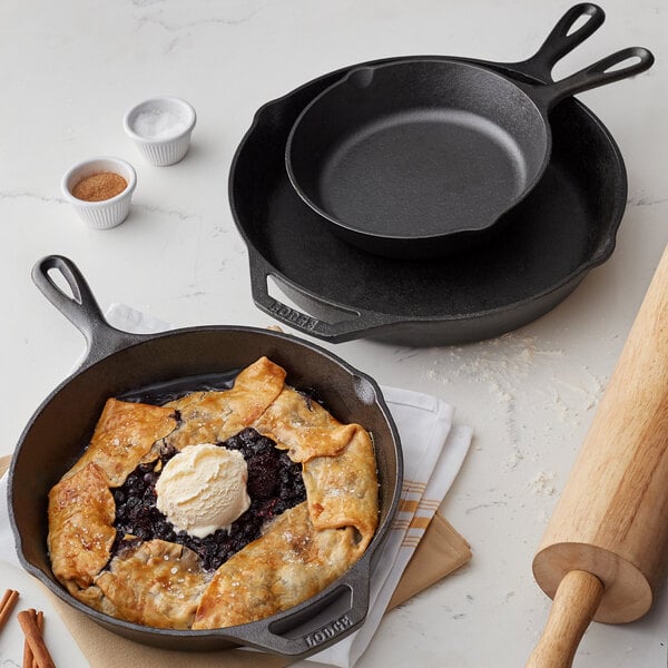 A Lodge cast iron skillet with a slice of blueberry pie and ice cream on it.