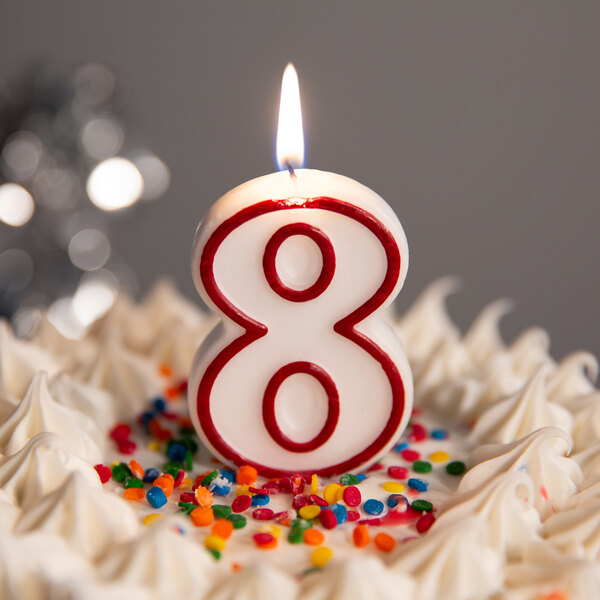 A white birthday cake with a red outlined number 8 candle.