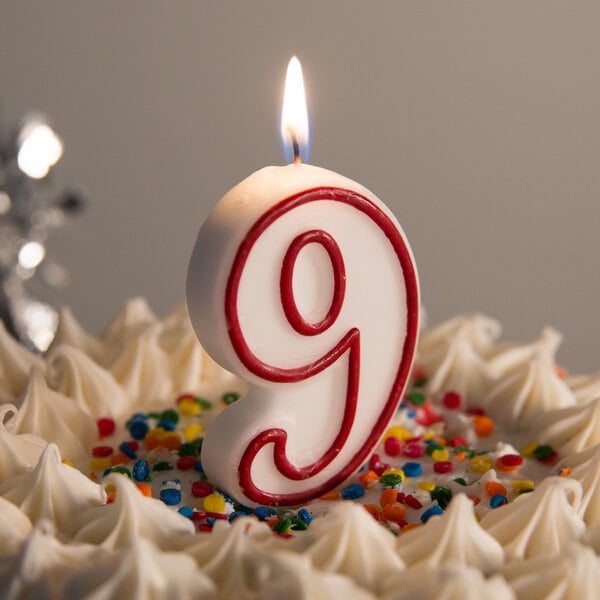 A white cake with a red and white "9" candle on top.