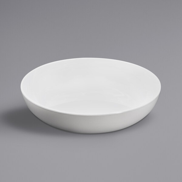 A white Elite Global Solutions melamine bowl on a gray surface.