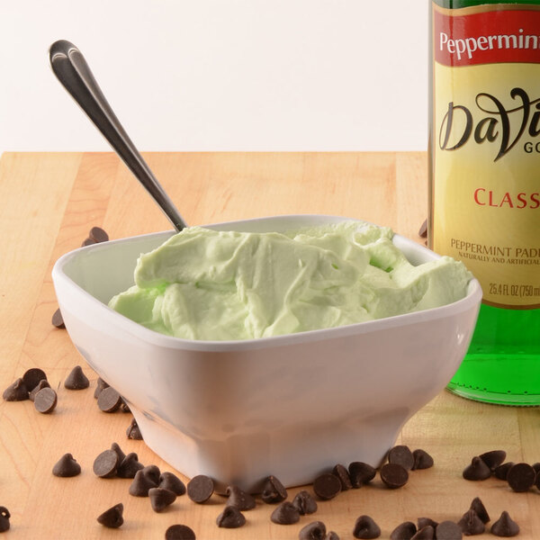 A white Thunder Group melamine bowl filled with green ice cream and chocolate chips.