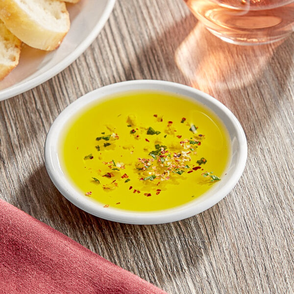 A table with a plate of oil and bread on it.