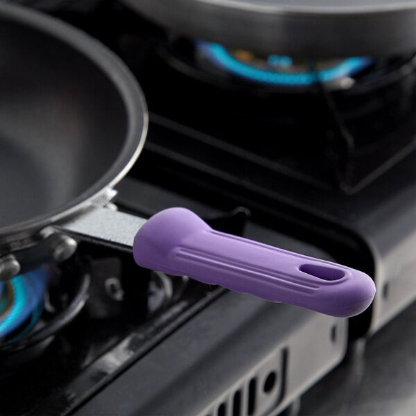 A Vollrath purple silicone handle cover on a pan.