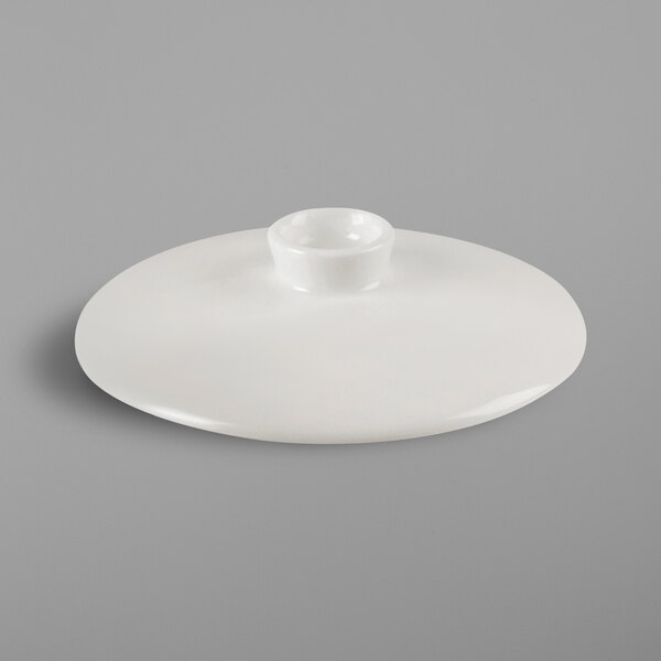 A white RAK Porcelain bowl lid with a small hole in the middle.