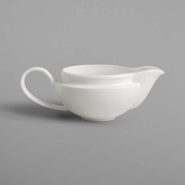 A white porcelain gravy boat with a handle.