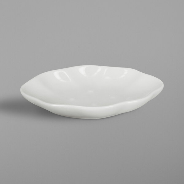 A RAK Porcelain ivory oval shell dish with a small rim on a gray surface.