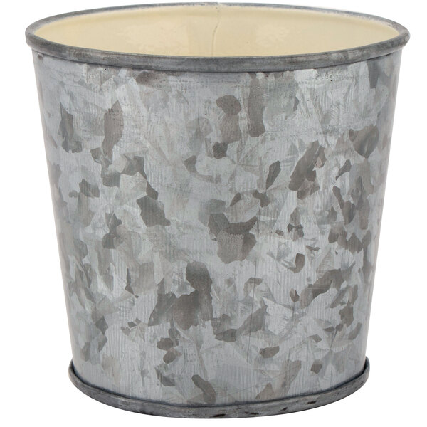 A round galvanized metal cup with a white rim.