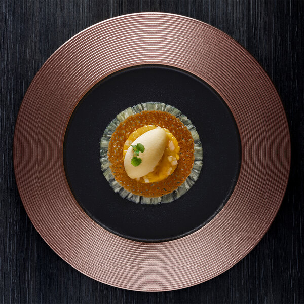 A RAK Porcelain bronze and black embossed flat plate with food on it.