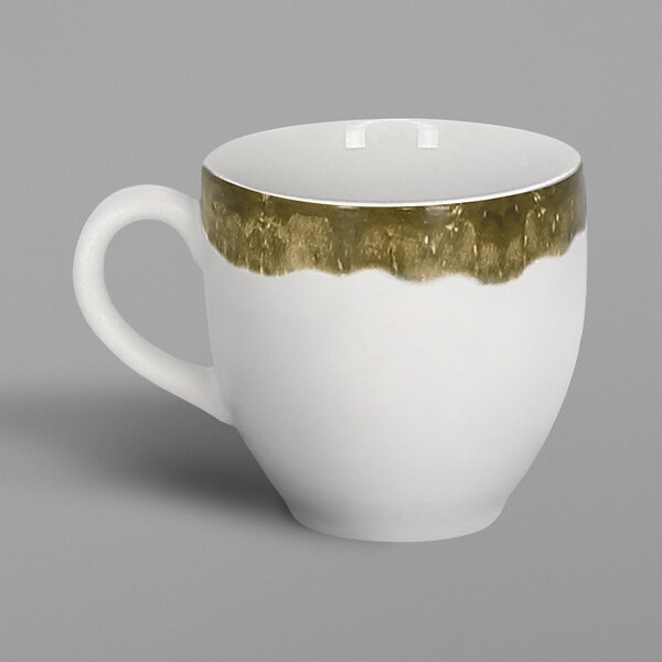 A close-up of a RAK Porcelain moss green espresso cup with a white background. The cup is white with gold paint on the handle.