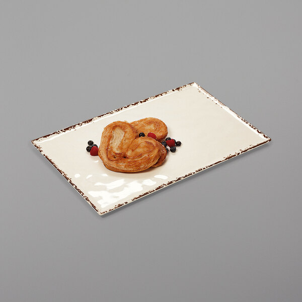 A white rectangular melamine platter with food on it.