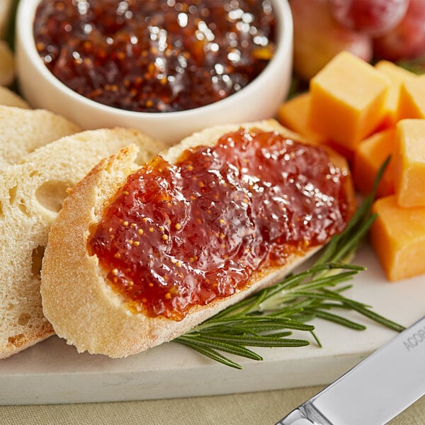 A plate of bread and cheese with Dalmatia Original Fig Spread on a hotel buffet table.