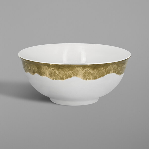 A close up of a RAK Porcelain Woodart white bowl with a gold band.