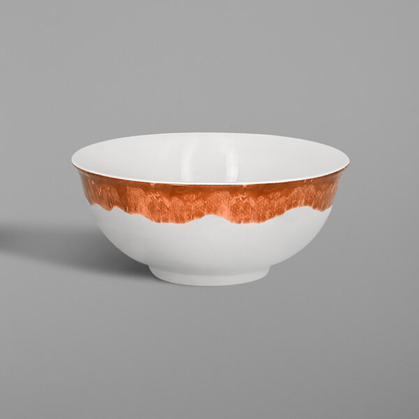 A white RAK Porcelain bowl with a brown and orange surface.