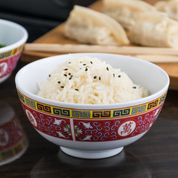 A close up of a Thunder Group Longevity melamine rice bowl filled with rice and black seeds.