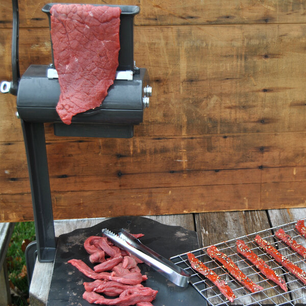 A Weston jerky slicer on a table with meat on it.