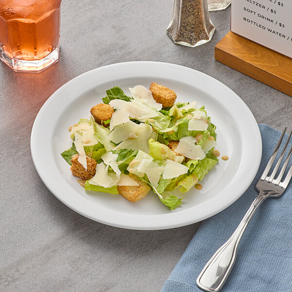 A plate of salad with a fork and knife on it.