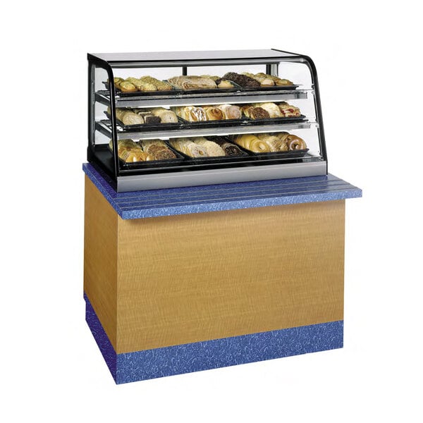 A Federal Industries countertop bakery display case with pastries on it.