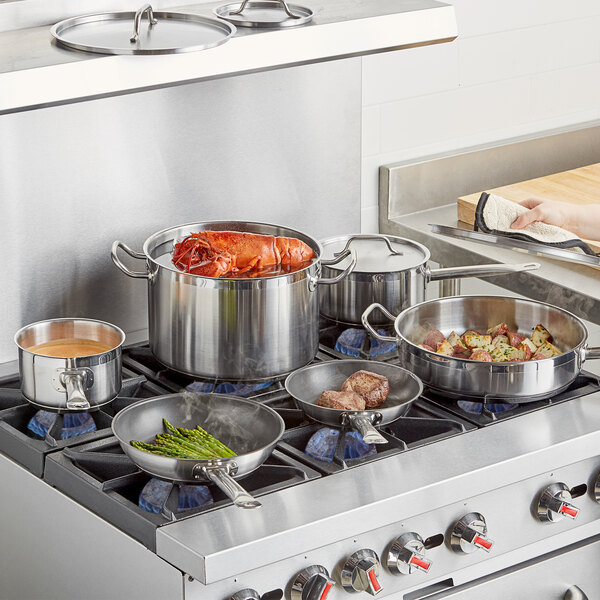 Vigor stainless steel cooking pots and pans on a stove.