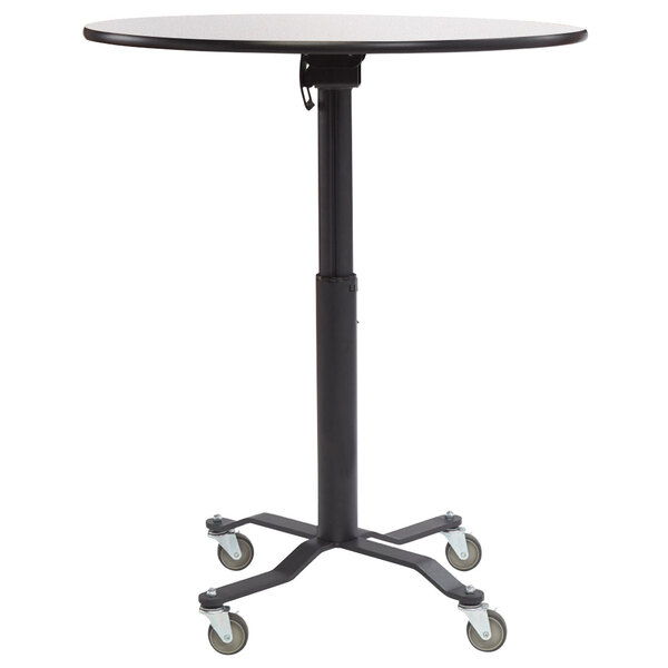 A black round National Public Seating cafe table with wheels and a whiteboard top.