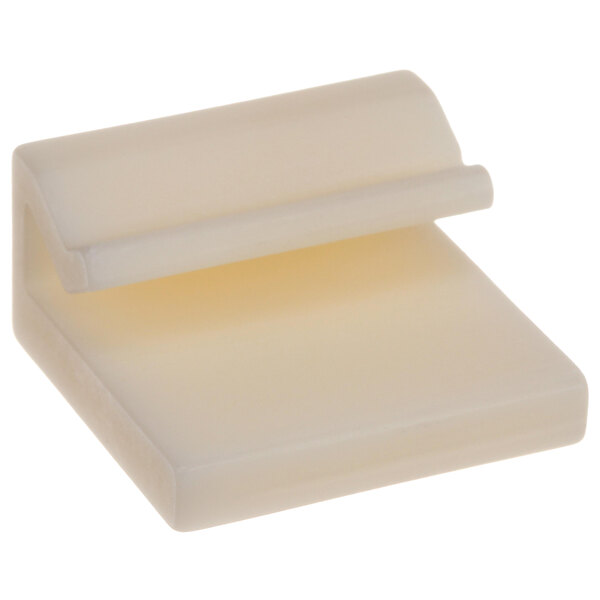 A white plastic Jackson Guide Block with a curved edge and a small handle.