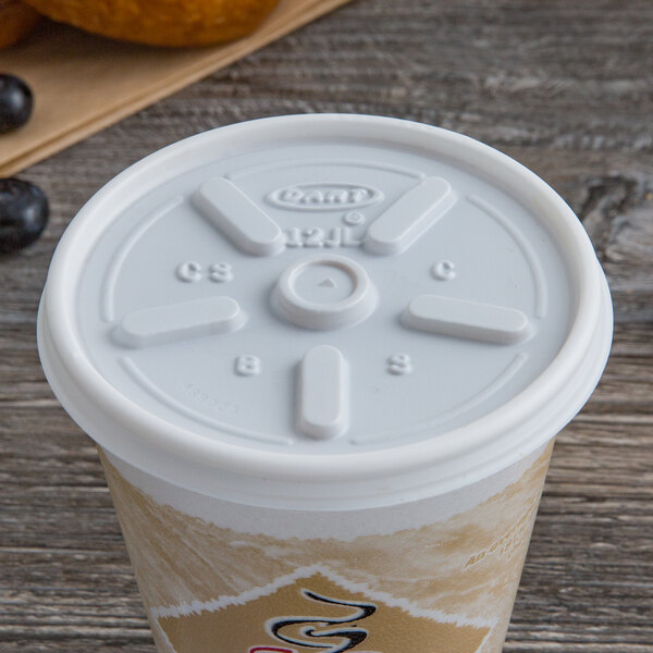 A white plastic cup of coffee with a Dart white vented lid on top.