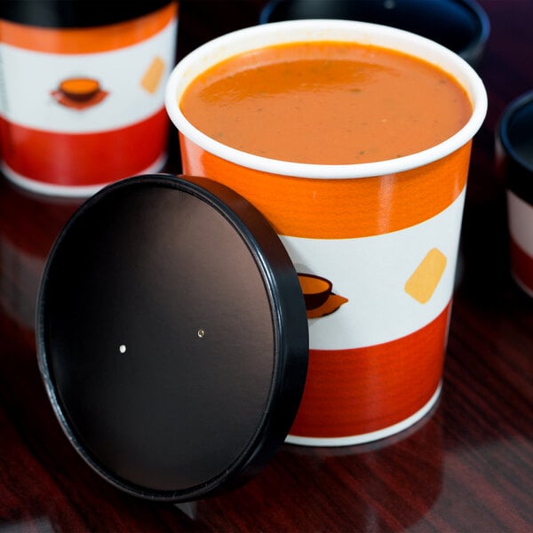 A close-up of a group of Choice paper soup containers with lids filled with a few different types of soup.