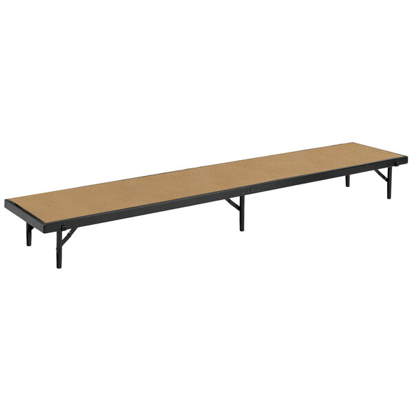 A National Public Seating hardboard rectangular stage riser with black legs.