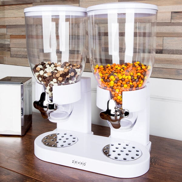 A Zevro double dry food dispenser with white containers filled with orange and brown candies.