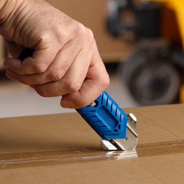 A person using a Pacific Handy Cutter to cut a box.