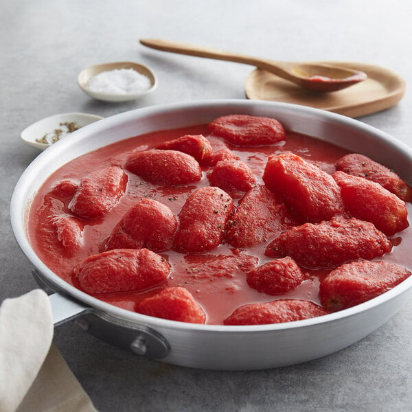 A pan of red sauce with whole peeled tomatoes cooked in it.