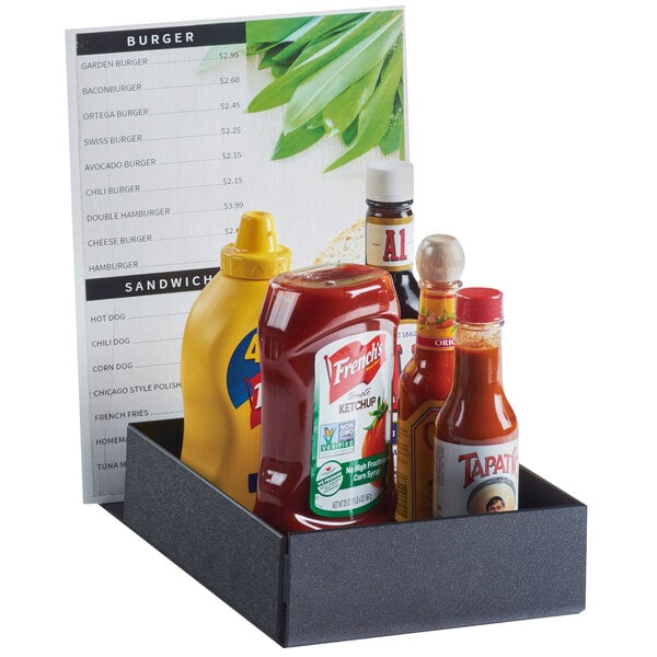 A black Cal-Mil menu and condiment holder on a table with condiments and a menu inside.