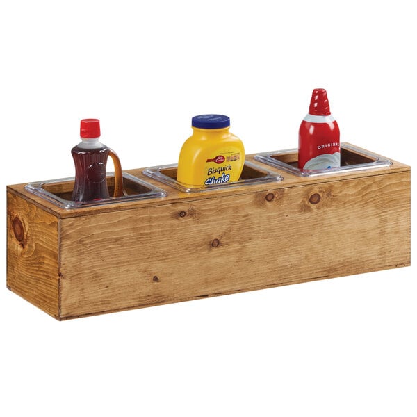 A Cal-Mil Madera Rustic Pine pan unit on a counter filled with condiments.