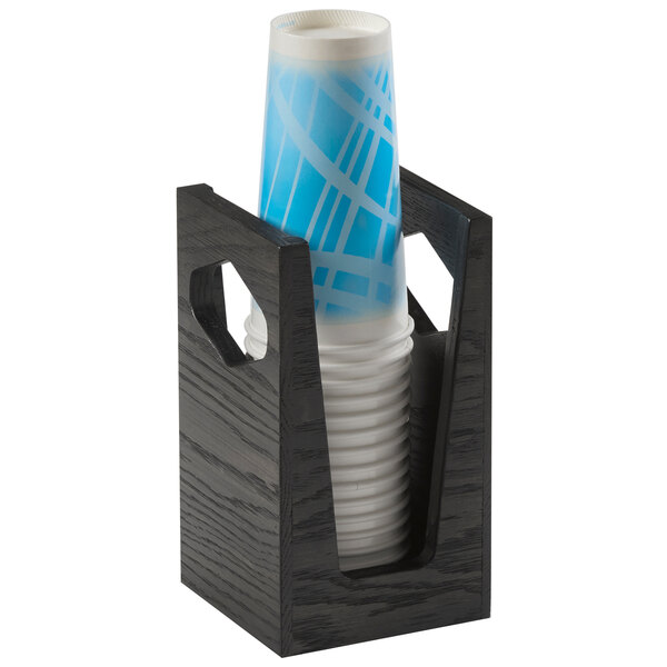 A black Cal-Mil Cinderwood countertop cup holder with a stack of white and blue cups inside.