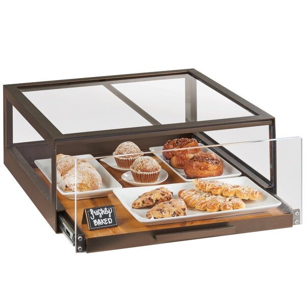 A Cal-Mil Sierra pastry drawer filled with various pastries on a bakery display counter.