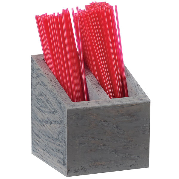 A Cal-Mil Ashwood gray oak wooden container holding straws on a counter.