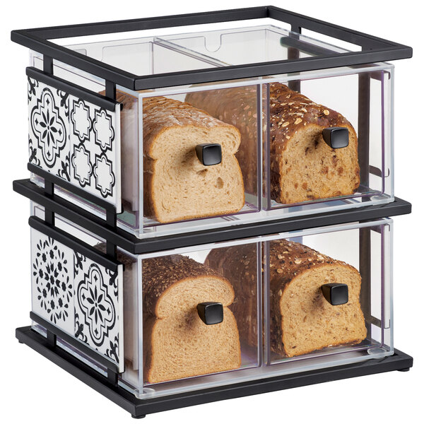 A loaf of bread in a glass container on a black and white display case.