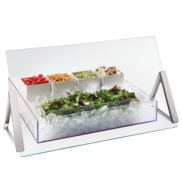 A Cal-Mil portable glass sneeze guard over a tray of food on a table.