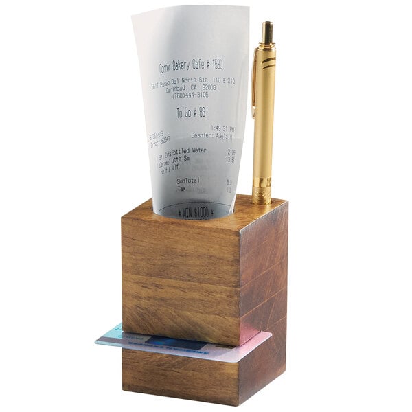 A wooden Cal-Mil restaurant receipt holder with a receipt and pen in it.