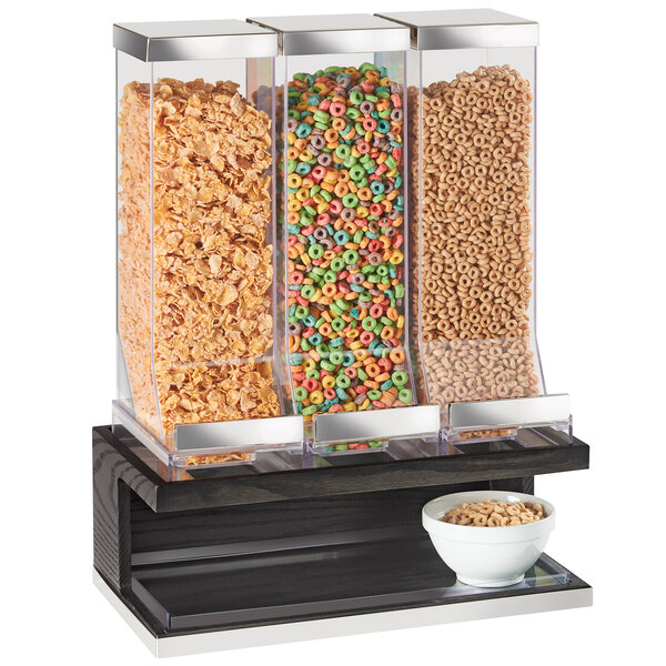 A Cal-Mil dark oak wood cereal dispenser with three containers of cereal.