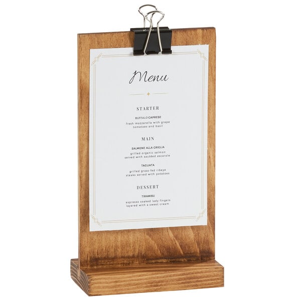 A Cal-Mil Madera rustic pine clipboard menu holder on a wood stand with a menu card clipped to it.