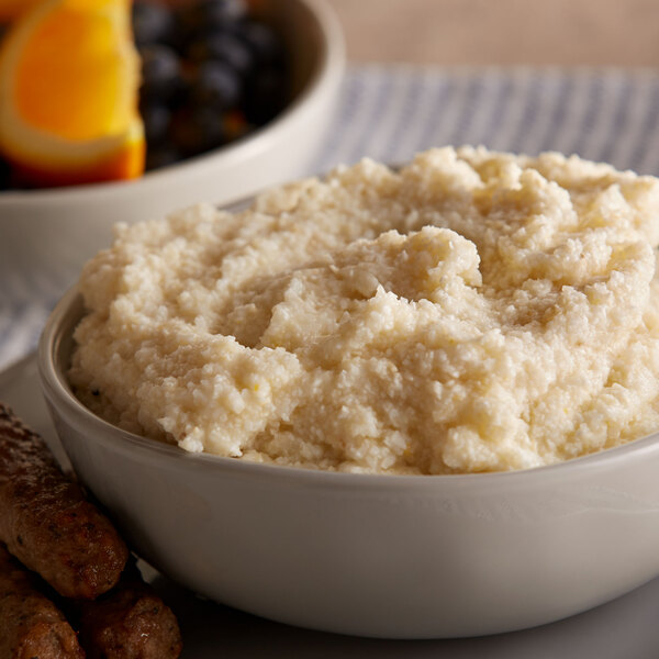 A close-up of a bowl of Quaker Oats Grits with sausages.