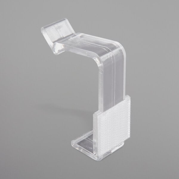 A clear plastic Snap Drape table skirt clip with a white strip.