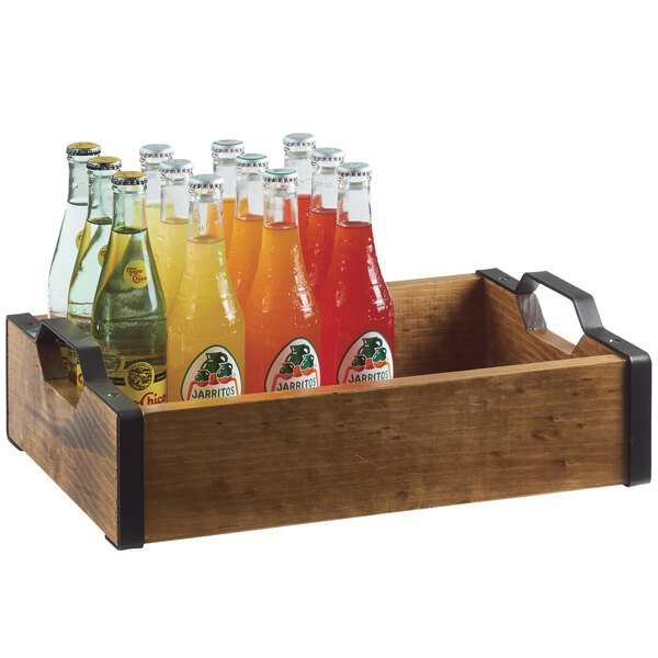 A wooden crate filled with glass bottles of red soda on a Cal-Mil Madera serving tray.